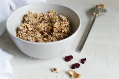 Evde enerji çikolatası yapma süreci. Hafif arka planda gri bir kasede zemin malzemelerinin karışımı hazır. Sağlıklı gıda konsepti. Seçici odak.