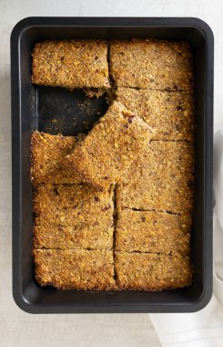 Güveç kabında pişirilip parçalara ayrılan enerji çubukları. Sağlıklı gıda konsepti. Uzayı kopyala Dikey yönelim.