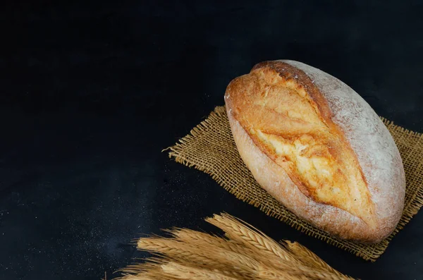 Φρέσκο Ψημένο Ψωμί Λινάτσα Ένα Μάτσο Σιτάρι Λινάτσα Μαύρο Φόντο — Φωτογραφία Αρχείου