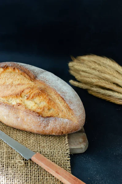 Φρέσκο Ψημένο Ψωμί Ένα Ξύλινο Λαγούμι Κοπής Ένα Μάτσο Σιτάρι — Φωτογραφία Αρχείου