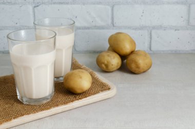 Patates sütlü iki bardak. Kırsal tarzda. Sağlıklı beslenmede yeni bir eğilim. Alternatif gıda konsepti. Vejetaryenler için sebze sütü. yatay oryantasyon. Seçici odaklanma. Boşluğu kopyala