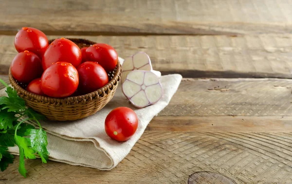 Red Ripe Tomatoes Wicker Bowl Sprig Parsley Garlic Wooden Background — Foto de Stock