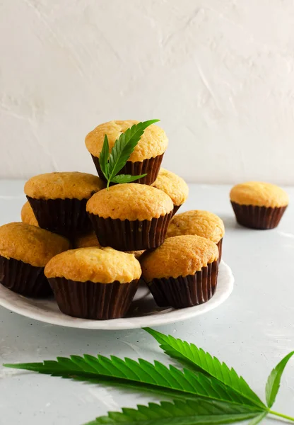 Many Marijuana cupcake muffins with cannabis leaves. Gluten free. Alternative sweets concept. Vertical orientation. Selective focus.