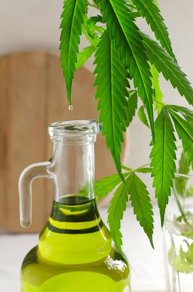 Cannabis CBD hemp oil drips in a glass bottle. The concept of Alternative Oil. Vertical orientation. Selective focus