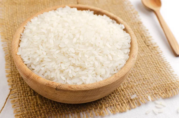 Dry camolino rice in a wooden bowl with a wooden spoon. The concept of healthy eating. Rustic style. Selective focus. Horizontal orientation.