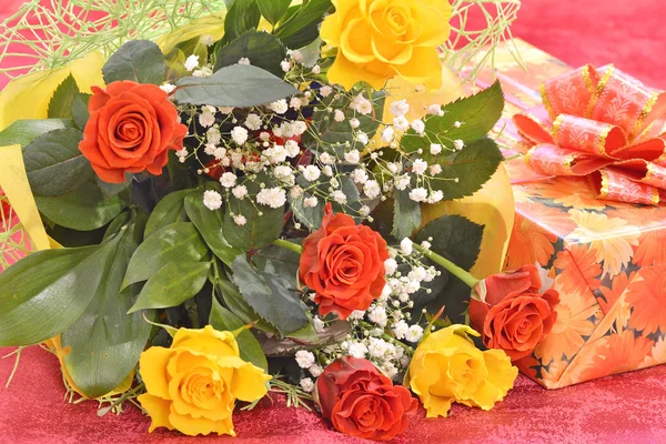 Ramo de rosas y un regalo — Foto de Stock