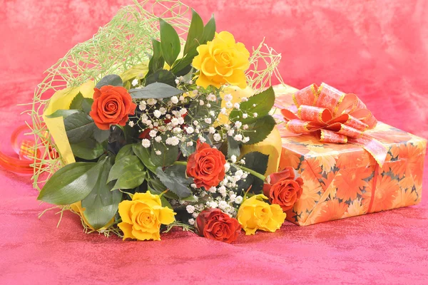 Bouquet of roses and a gift — Stock Photo, Image
