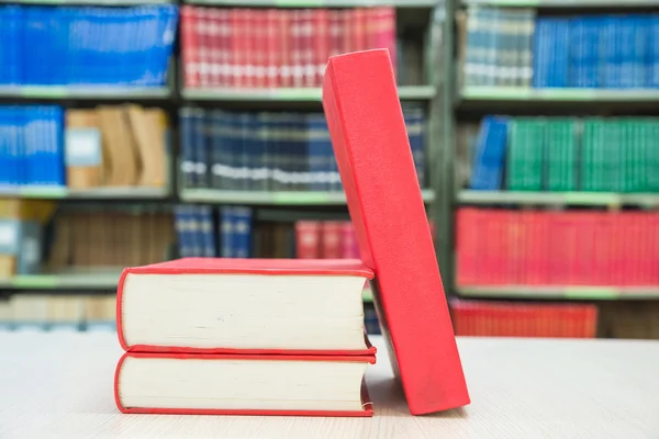 Uma pilha de livros com biblioteca em segundo plano — Fotografia de Stock