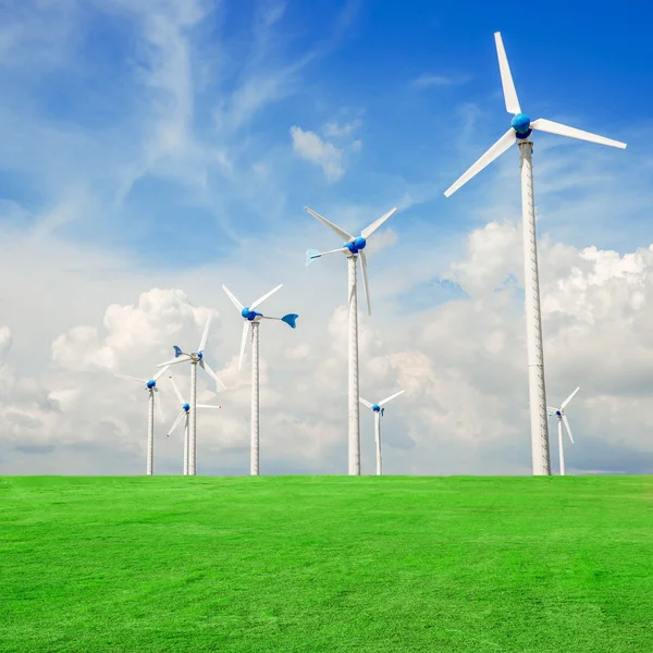 Wind mill power plant in green field  against blue sky — Stock Photo, Image