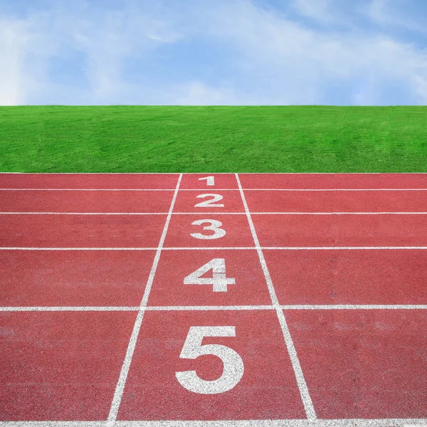 Posición de inicio o final en pista de atletismo con cielo azul —  Fotos de Stock