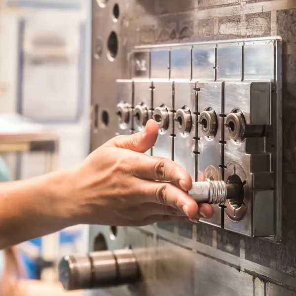 Arbeiter legen Ersatzteile in Spritzgießmaschine ein — Stockfoto