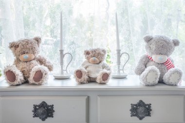 birçok oyuncak ayı ve tablo ve pencere arka plan üzerinde mum