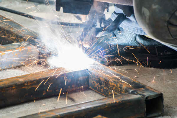 Woker welding steel with sparks lighting