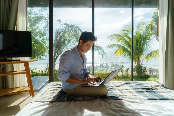 Young Asian Businessman Sitting Bed Working Laptop Room Resort Sea — Stock fotografie