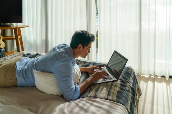 Młody Azjatycki Biznesmen Leżący Łóżku Pracujący Laptopem Pokoju Kurorcie Nad — Zdjęcie stockowe
