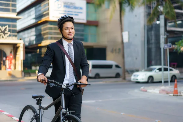 アジアのビジネスマンは 朝家から自転車を押して仕事に乗る準備をしています エコ交通 — ストック写真