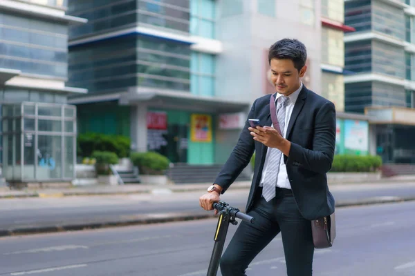 Empresário Asiático Está Montando Uma Scooter Elétrica Usando Seu Telefone — Fotografia de Stock