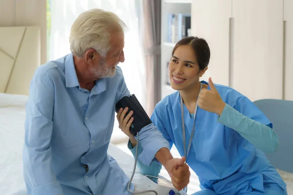 Asiatique Attentive Caregiver Using Tonometer While Elder Man Having Breath — Photo