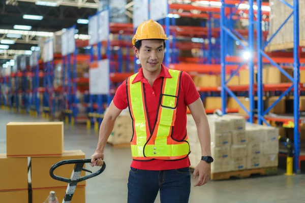Shipping boxes. Asian man Warehouse worker unloading pallet shipment goods into a truck container, warehouse industry freight, logistics and transport.