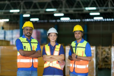Group of Asian smiling warehouse worker standing together at logistics distribution warehouse, Teamwork concep