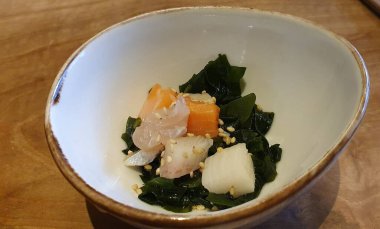 Yosun ve balık aperatifi bir Japon restoranında salata sosu ile birlikte.