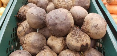 Tahta sandıkta toplanmış taze pancar kökleri toprak arka planda yaprakları olan ev yapımı organik pancar yığınları.