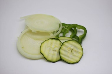 kabak, soğan ve dolmalık biber dilimleri beyaz arka planda izole edilmiş.