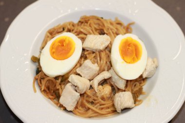 Sebzeli erişte, hindi ve haşlanmış yumurta beyaz arka planda izole edilmiş bir kasede..