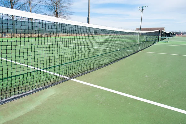 Tennis courts with net and green surface Stock Photo