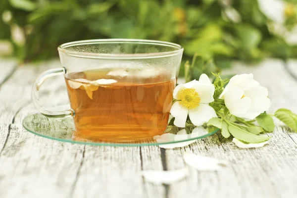 Cup of tea with white rose on wooden table — Stock Photo, Image