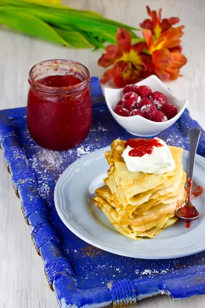 Crepes com creme de leite e confiture de morango caseiro na bandeja de madeira azul velha — Fotografia de Stock