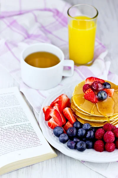 Deliciosas panquecas na mesa de madeira com frutas e mel para o café da manhã — Fotografia de Stock