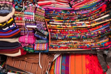 Ekvador pazarında parlak renkli kumaşlar. Pembe, kırmızı, blues, aslında pançolar, kilim ve eşarp görüntüleme gökkuşağının her renk