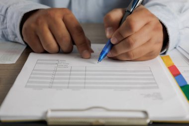 İşadamı evrak okuyor kağıt işi belgesinde kontrat imzalıyor laptopta çalışıyor, masa başında çalışıyor.