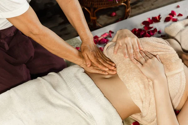 Asian woman enjoying a salt scrub massage at spa. Healthcare spa