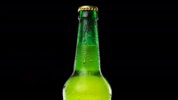 Drops trickle down the beer bottle. Cold and fresh beer bottle on black background — Stock Video