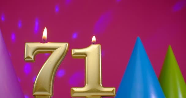 Égő szülinapi torta gyertya száma 71. Boldog születésnapot háttér évforduló ünneplés koncepció. Születésnapi kalap a háttérben — Stock videók