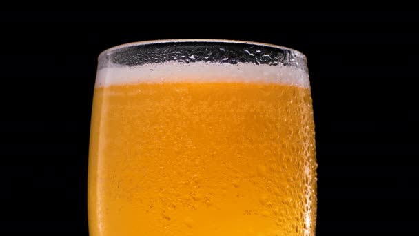 Birra fresca in un bicchiere su sfondo nero . — Video Stock