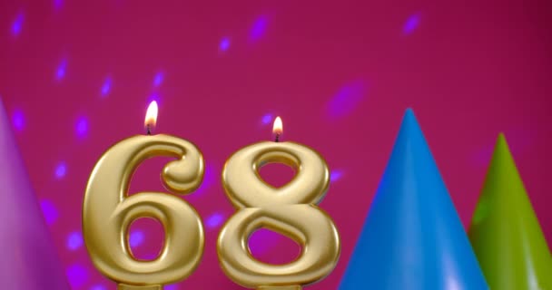 Verbrand verjaardagstaart kaars nummer 68. Gelukkige verjaardag achtergrond jubileum concept. Verjaardagshoed op de achtergrond — Stockvideo