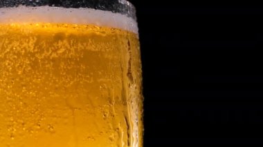 Düşen su damlalarıyla dolu yarım bardak bira. Bardakta soğuk bira ve bir damla su. Metin için yer