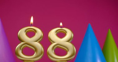 88 numaralı doğum günü pastası mumu yanıyor. Mutlu yıllar yıldönümü kutlaması konsepti. Arka planda doğum günü şapkası