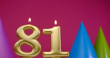 81 numaralı doğum günü pastası mumu yanıyor. Mutlu yıllar yıldönümü kutlaması konsepti. Arka planda doğum günü şapkası
