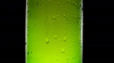 Bira şişesine su damlaları. Su damlacıklarıyla ferahlatıcı ve soğuk bira..