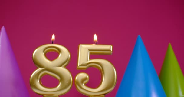 Vela de pastel de cumpleaños ardiente número 85. Feliz cumpleaños aniversario de fondo concepto de celebración. Sombrero de cumpleaños en el fondo — Vídeos de Stock