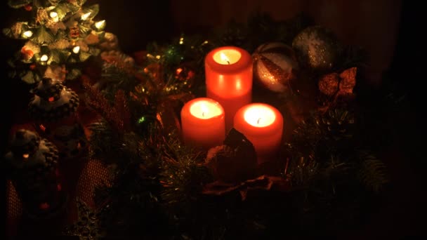 Χριστουγεννιάτικη διακόσμηση με αναμμένα κεριά σε σκούρο φόντο. Χριστουγεννιάτικες διακοπές — Αρχείο Βίντεο