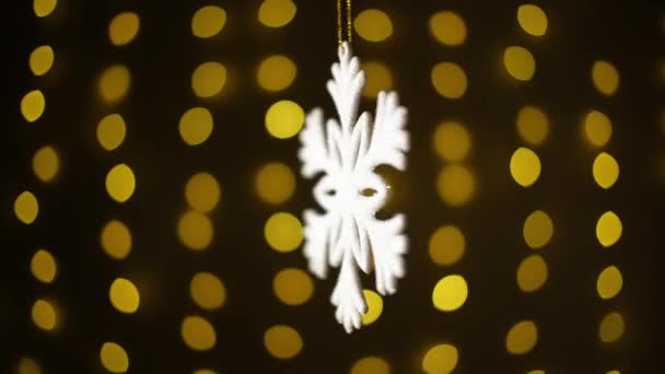 Weihnachten Schneeflocken auf dem Hintergrund eines Kranzes Bokeh. — Stockvideo