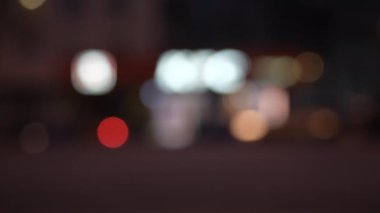 Şehir caddesindeki trafik bulanık. Odaklanamayan gece trafik ışıkları