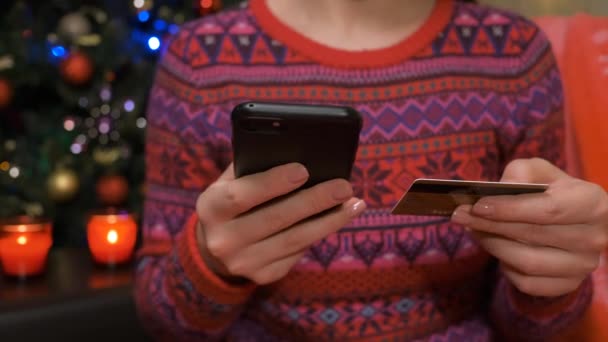 Young woman ordering online from her phone with a credit card at home — Stock Video