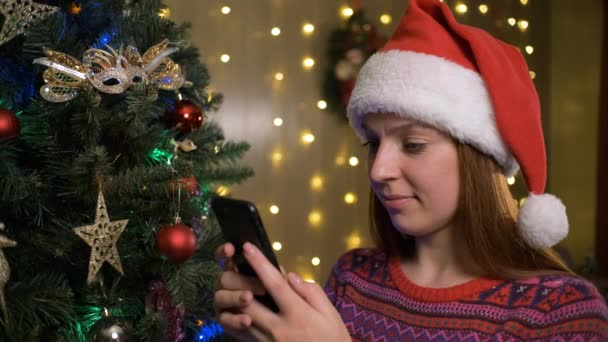 Vrouw gebruik van mobiele telefoon thuis. Kersttijd — Stockvideo