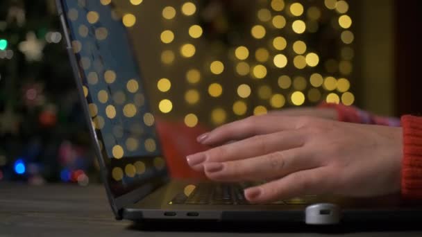 Frau blättert in der Artikelgalerie des Online-E-Commerce auf ihrem Laptop und macht Einkäufe für Weihnachten und Neujahr. — Stockvideo